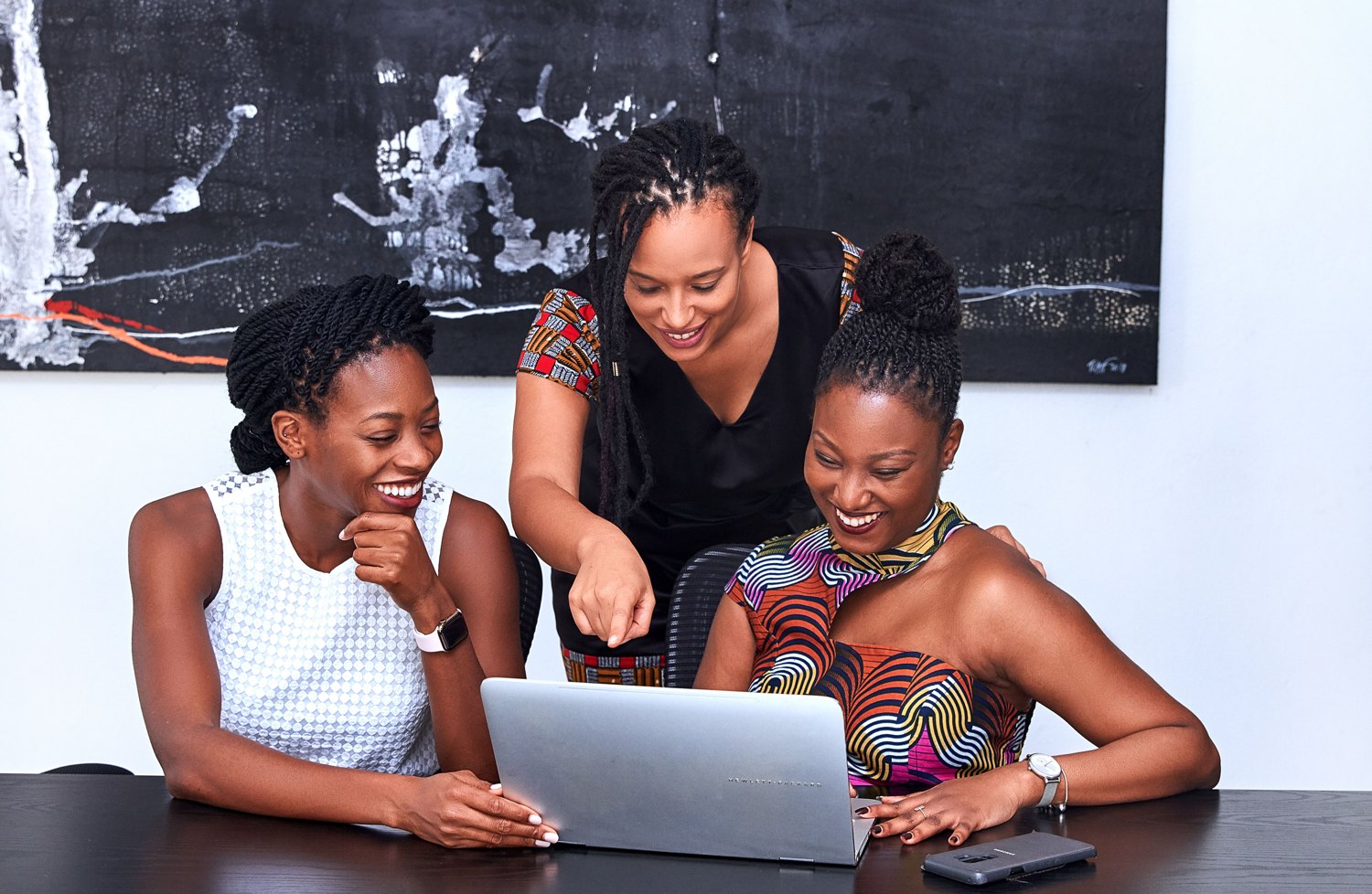 Professionals collaborating around a laptop